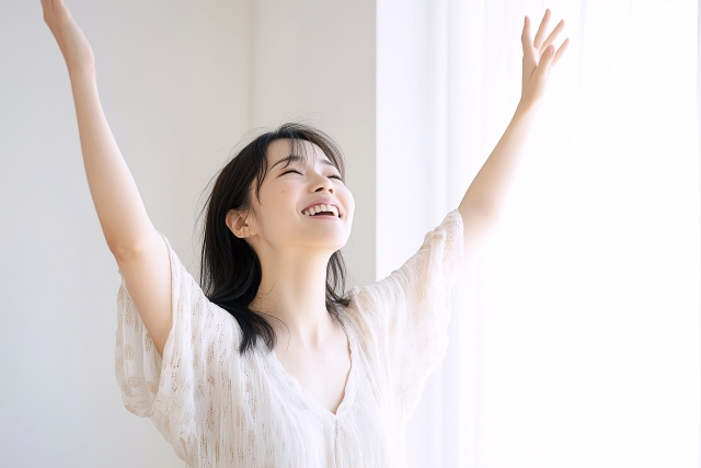 笑顔で両手をあげる女性