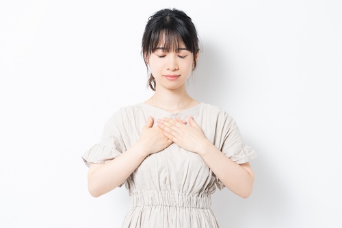 両手を胸にあてる女性