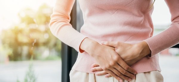お腹に手を当てる女性
